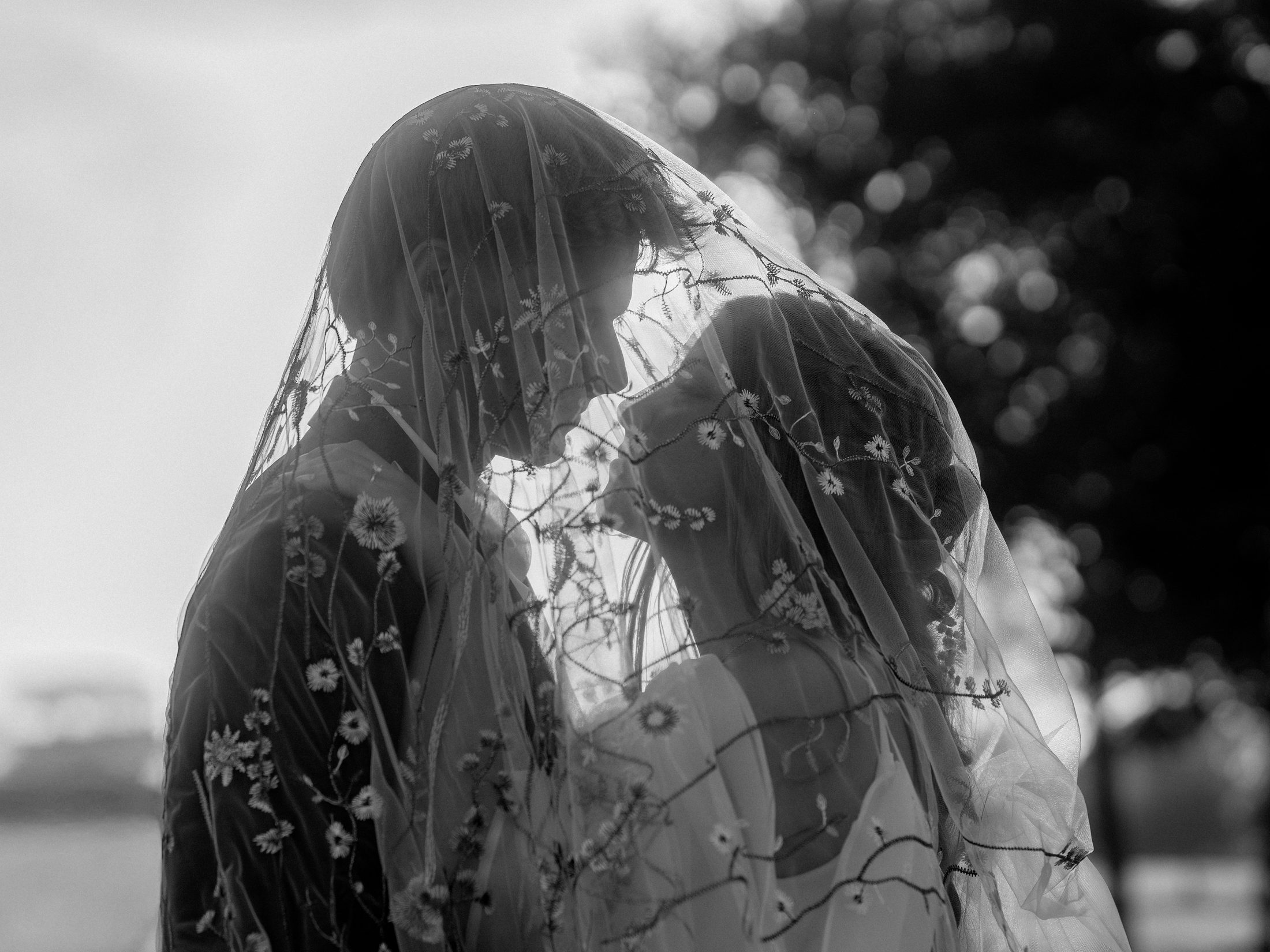Bride and groom under veil in black and white