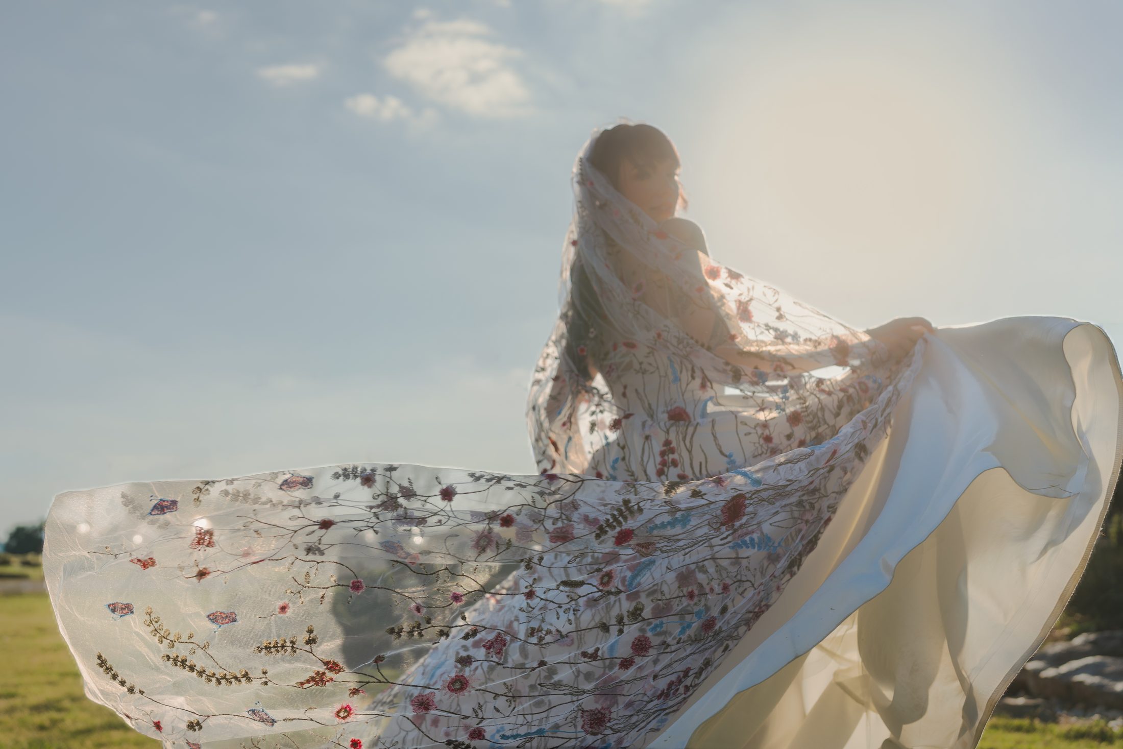Bride standing in wind with veil