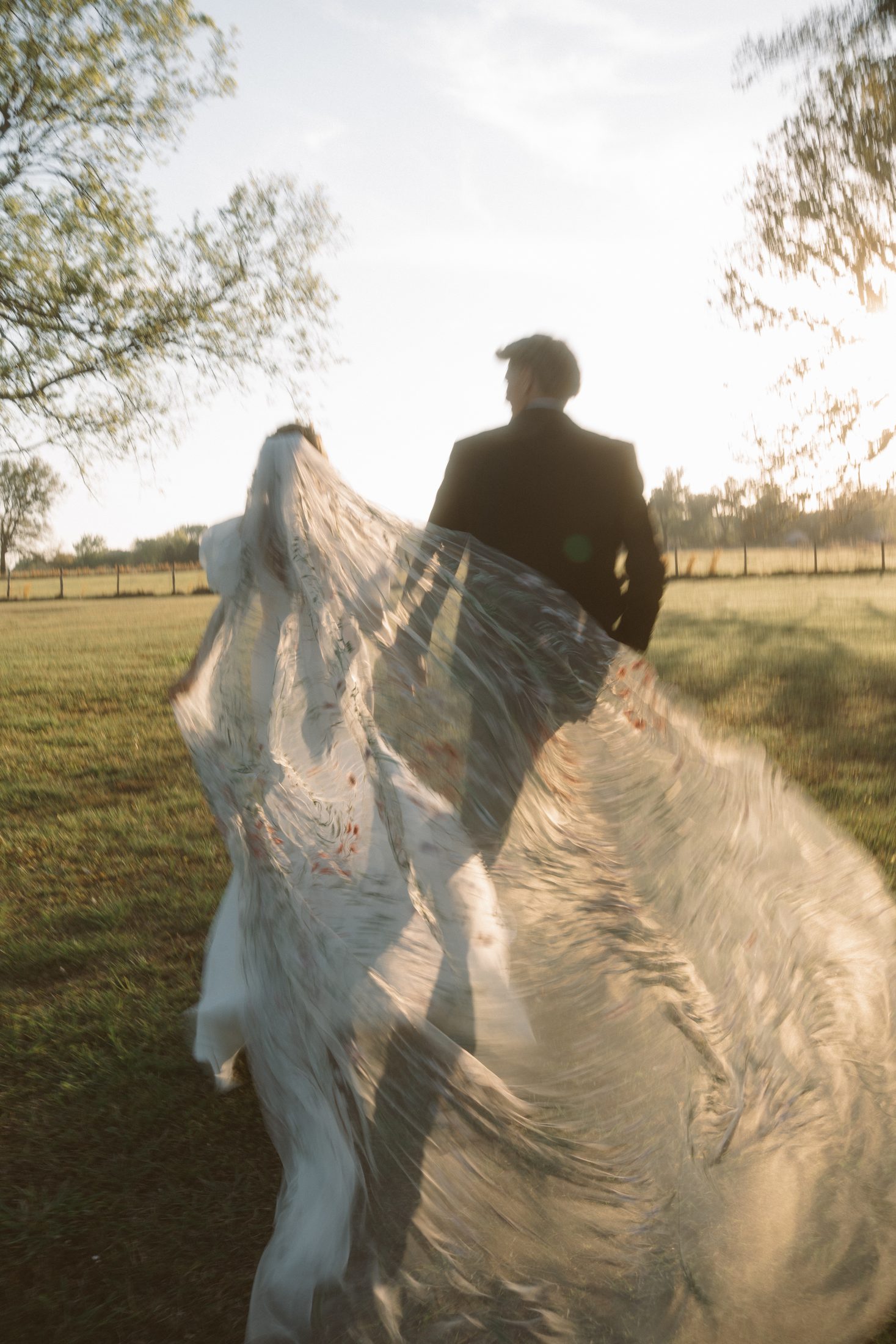 Couple walking through sunlit grass