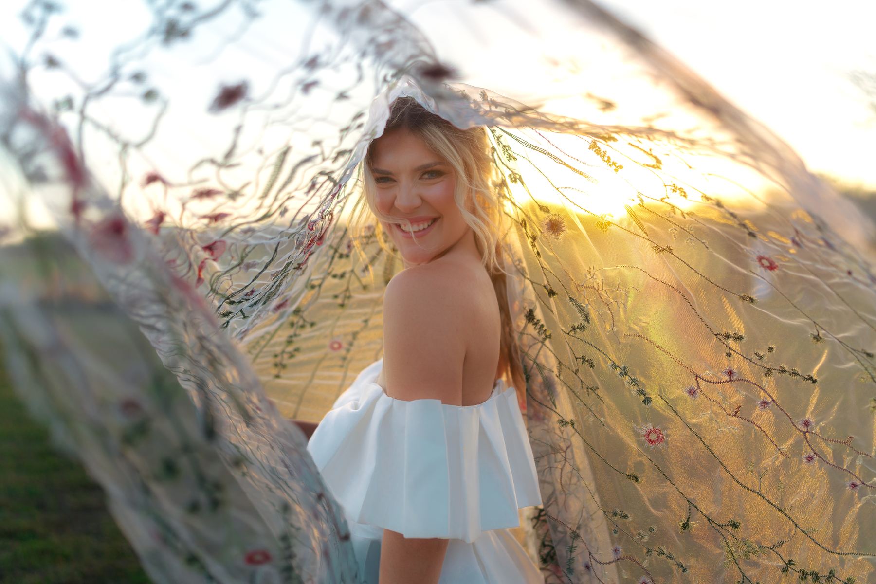 Bride portrait through veil at sunset